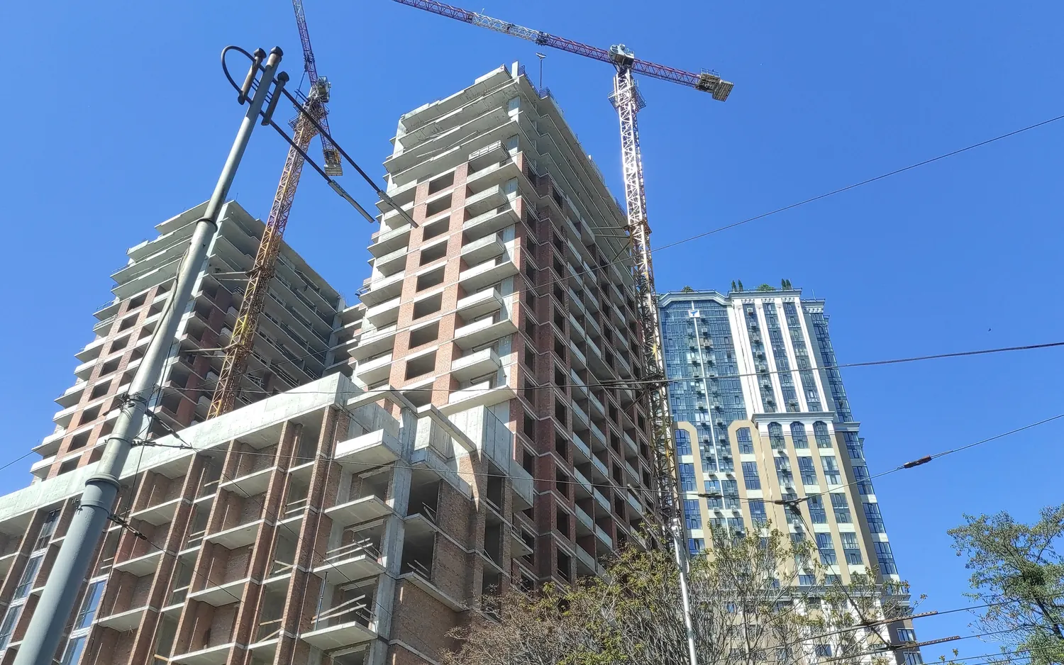 Empreendimento residencial em construção, com guindastes, contra o céu